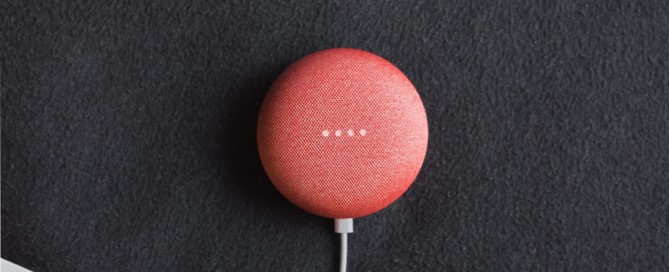 flat lay photography of coral Google Home Mini on black surface beside Apple AirPods