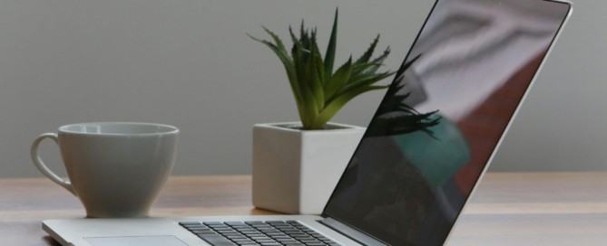 Free Minimalist home office desk with laptop, smartphone, and plant for a modern work environment. Stock Photo