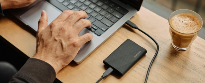 A man sitting at a table using a laptop computer